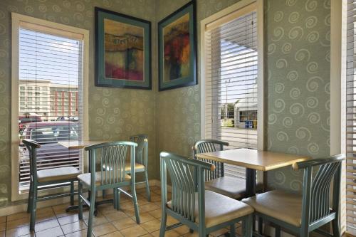 a dining room with tables and chairs and windows at Super 8 by Wyndham Mount Vernon, IL in Mount Vernon