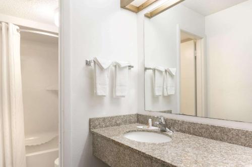 a bathroom with a sink and a mirror at Super 8 by Wyndham Riviera Beach West Palm Beach in Riviera Beach