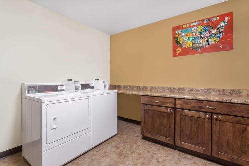 lavadero con lavadora y barra en Travelodge by Wyndham Loveland/Fort Collins Area, en Loveland