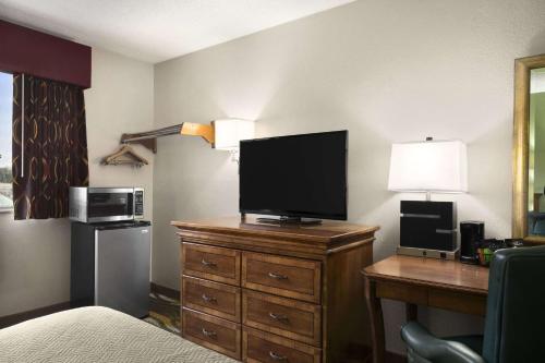 a hotel room with a television on a dresser at Travelodge by Wyndham Battle Creek in Battle Creek