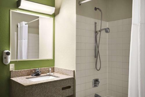 a bathroom with a sink and a shower at Travelodge by Wyndham Battle Creek in Battle Creek