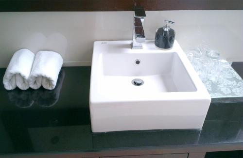 a white sink in a bathroom with two towels at Bali Agung Village - CHSE Certified in Seminyak