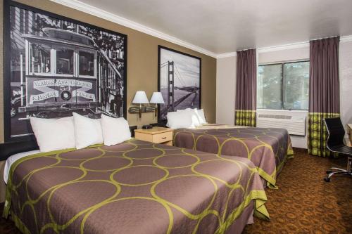 ein Hotelzimmer mit 2 Betten und einem Fenster in der Unterkunft Super 8 by Wyndham Vacaville in Vacaville