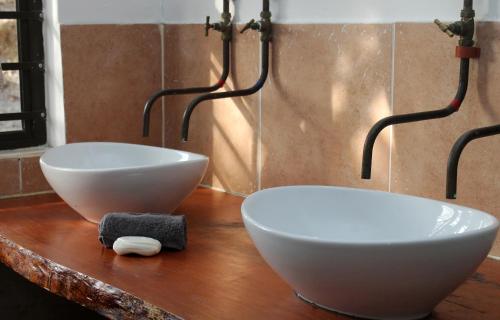 - deux bols blancs sur un comptoir en bois dans la salle de bains dans l'établissement Rusthof Accommodation, à Gansbaai