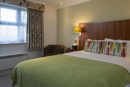 a hotel room with a large bed and a window at The Woodlands Event Centre in Wyboston