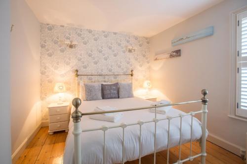 1 dormitorio con 1 cama con marco blanco en Pugwash en Aldeburgh
