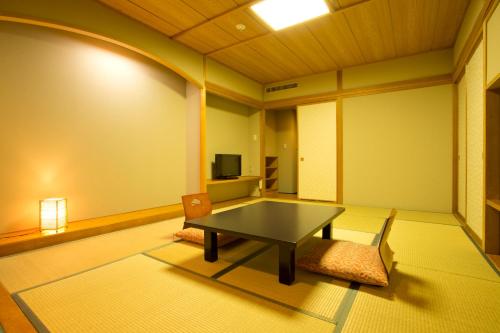 a living room with a table and a chair at Hotel Oak Forest in Hakuba