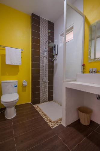 a bathroom with a shower and a toilet and a sink at Laemsing Whitehouse Resort in Laem Sing