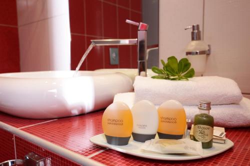 a bathroom counter with a sink and bottles of soap at Alexandra Beach Spa Resort in Potos