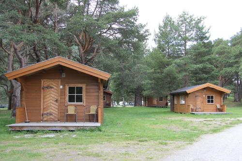 two small wooden buildings sitting in a field at Toftemo Turiststasjon in Dovre