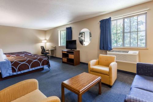a hotel room with a bed and a living room at Super 8 by Wyndham Stroudsburg in East Stroudsburg