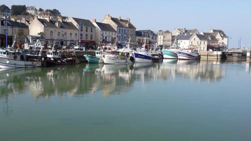 a group of boats are docked in a harbor at la maison du postier in Port-en-Bessin-Huppain