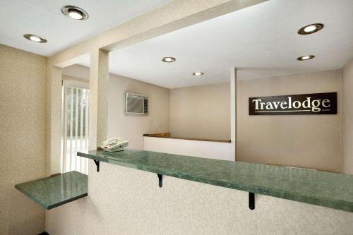 a large mirror in a waiting room with a counter at Travelodge by Wyndham La Porte/Michigan City Area in LaPorte