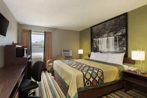 a hotel room with a bed and a window at Super 8 by Wyndham Tuscola in Tuscola