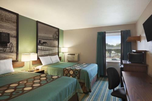 a hotel room with two beds and a television at Super 8 by Wyndham Tuscola in Tuscola