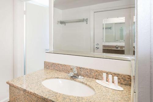 uma casa de banho com um lavatório e um espelho em Knights Inn Statesboro em Statesboro