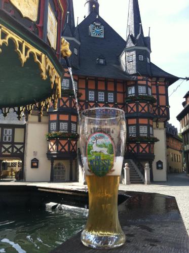 a glass of beer sitting in front of a building at Ringhotel Weißer Hirsch in Wernigerode