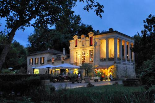 un grand manoir éclairé la nuit dans l'établissement Camping RCN Le Moulin de la Pique, à Belvès