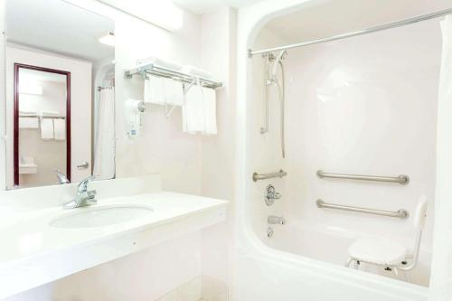 a white bathroom with a sink and a shower at Howard Johnson by Wyndham Perry GA in Perry