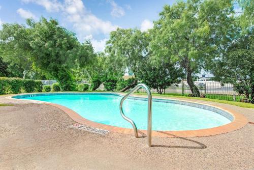 a swimming pool with a metal rail around it at Super 8 by Wyndham San Antonio/Fiesta in San Antonio