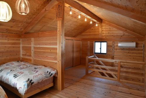 a bedroom in a log cabin with a bed in it at Shinshu Yokoya Farm in Matsumoto