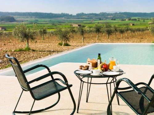 a table with food on it next to two chairs at Agroturisme Gossalba in Sant Joan