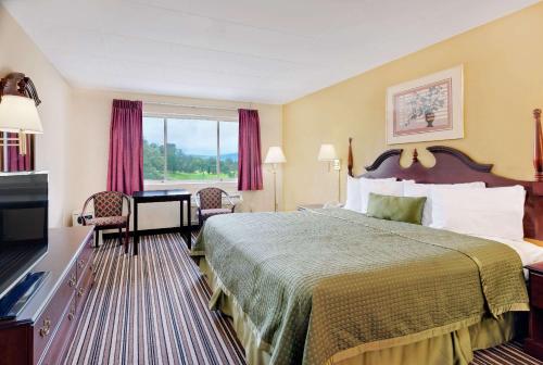 a hotel room with a bed and a television at Travelodge by Wyndham Chambersburg in Chambersburg