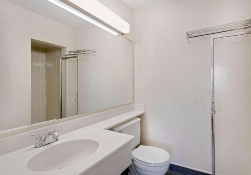 uma casa de banho branca com um lavatório e um WC em Travelodge by Wyndham Chambersburg em Chambersburg