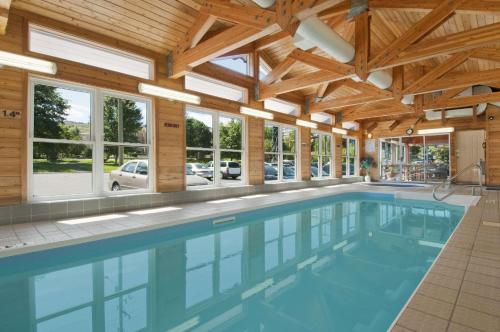 a swimming pool in a house with a wooden ceiling at Travelodge by Wyndham Kamloops in Kamloops