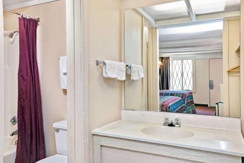 La salle de bains est pourvue d'un lavabo et d'un miroir. dans l'établissement Knights Inn Charleston West Virginia, à Charleston