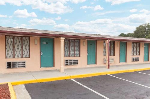 a building with green doors in a parking lot at Knights Inn - Tucker in Tucker