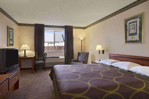 um quarto de hotel com uma cama e uma televisão em Super 8 by Wyndham Colorado Springs Airport em Colorado Springs