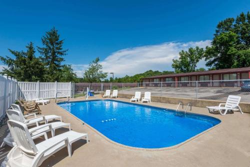 Una piscina con tumbonas al lado de un edificio. en Knights Inn Ashland, en Ashland