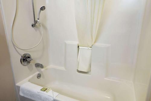uma casa de banho branca com um chuveiro e uma banheira em Super 8 by Wyndham Colorado Springs Airport em Colorado Springs