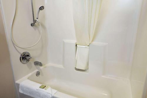 Un baño blanco con ducha y bañera. en Super 8 by Wyndham Colorado Springs Airport, en Colorado Springs