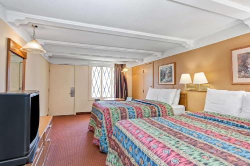 Cette chambre comprend 2 lits et une télévision à écran plat. dans l'établissement Knights Inn Charleston West Virginia, à Charleston