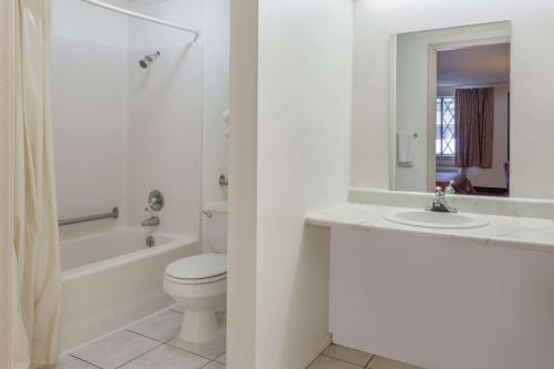 een witte badkamer met een toilet en een wastafel bij Knights Inn Farmington Hills in Farmington Hills