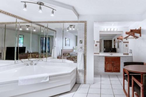 a white bathroom with a tub and a table at Knights Inn Pittston in Pittston