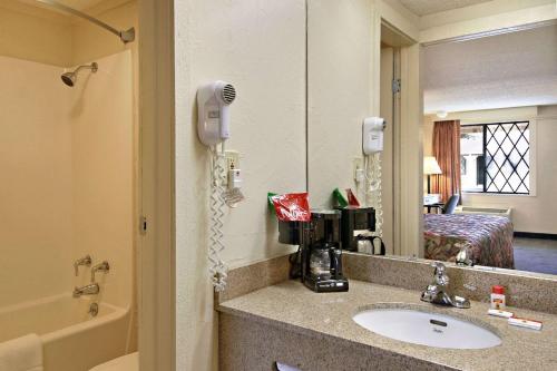 a bathroom with a sink and a mirror at Super 8 by Wyndham Lantana West Palm Beach in Lantana