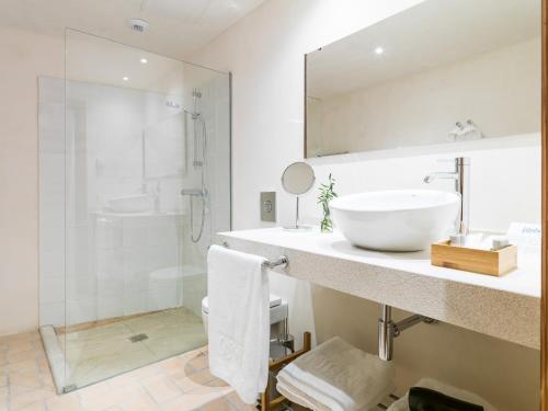 a white bathroom with a sink and a shower at Agroturisme Gossalba in Sant Joan