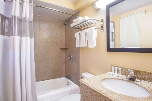 a bathroom with a sink and a tub and a toilet at Travelodge by Wyndham South Burlington in Burlington