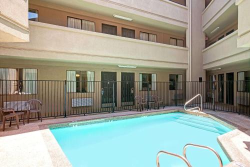 a pool at a hotel with chairs and a table at Travelodge by Wyndham Sacramento / Rancho Cordova in Sacramento