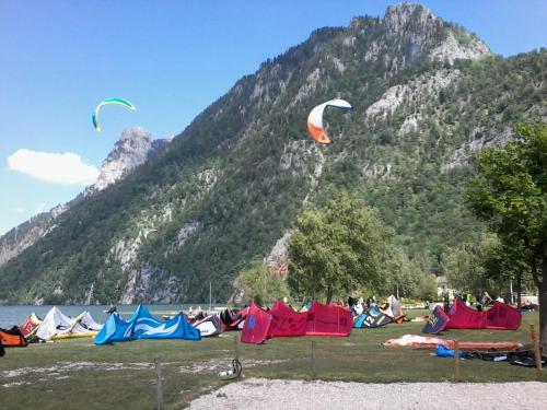 a group of people flying kites in a field next to a mountain at Steinkogler Ferienwohnungen in Ebensee