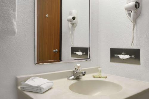 ein Bad mit einem Waschbecken und einem Spiegel in der Unterkunft Super 8 by Wyndham Park City/North Wichita Area in Park City
