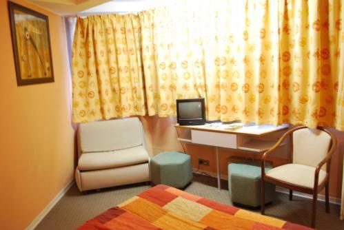 a bedroom with a desk with a computer and chairs at Picardy Hôtel-Gare du Nord in Paris