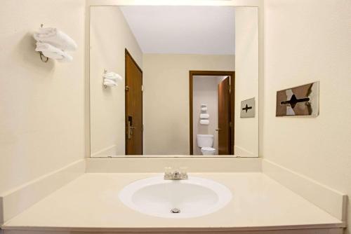 a bathroom with a sink and a large mirror at Super 8 by Wyndham Riverside/Kansas City in Kansas City