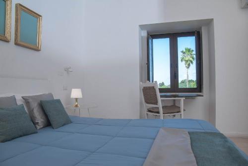 a bedroom with a large blue bed and a window at Bookbreakfast in Terme Vigliatore