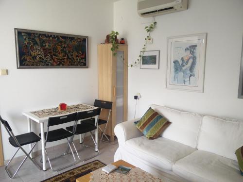 een woonkamer met een bank en een tafel bij Herzelia Rooftop Special 2 Room Apartment in Herzelia 