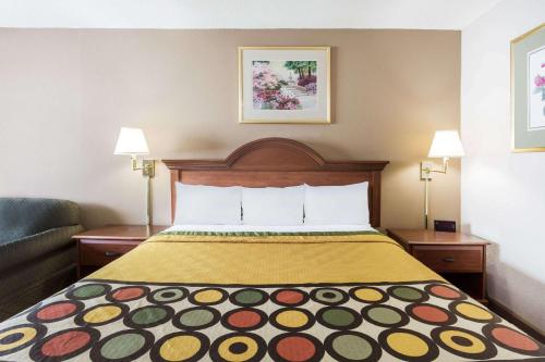 a hotel room with a bed and a couch at Super 8 by Wyndham Greensboro in Greensboro