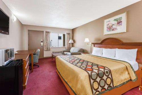 um quarto de hotel com uma cama grande e uma televisão em Super 8 by Wyndham Greensboro em Greensboro